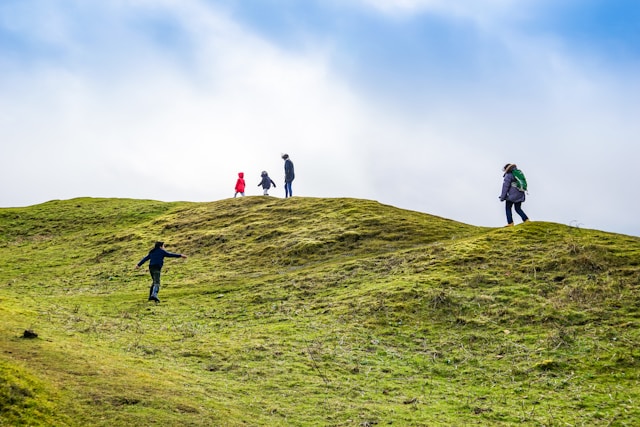 People walking over a hill in the Cotswolds