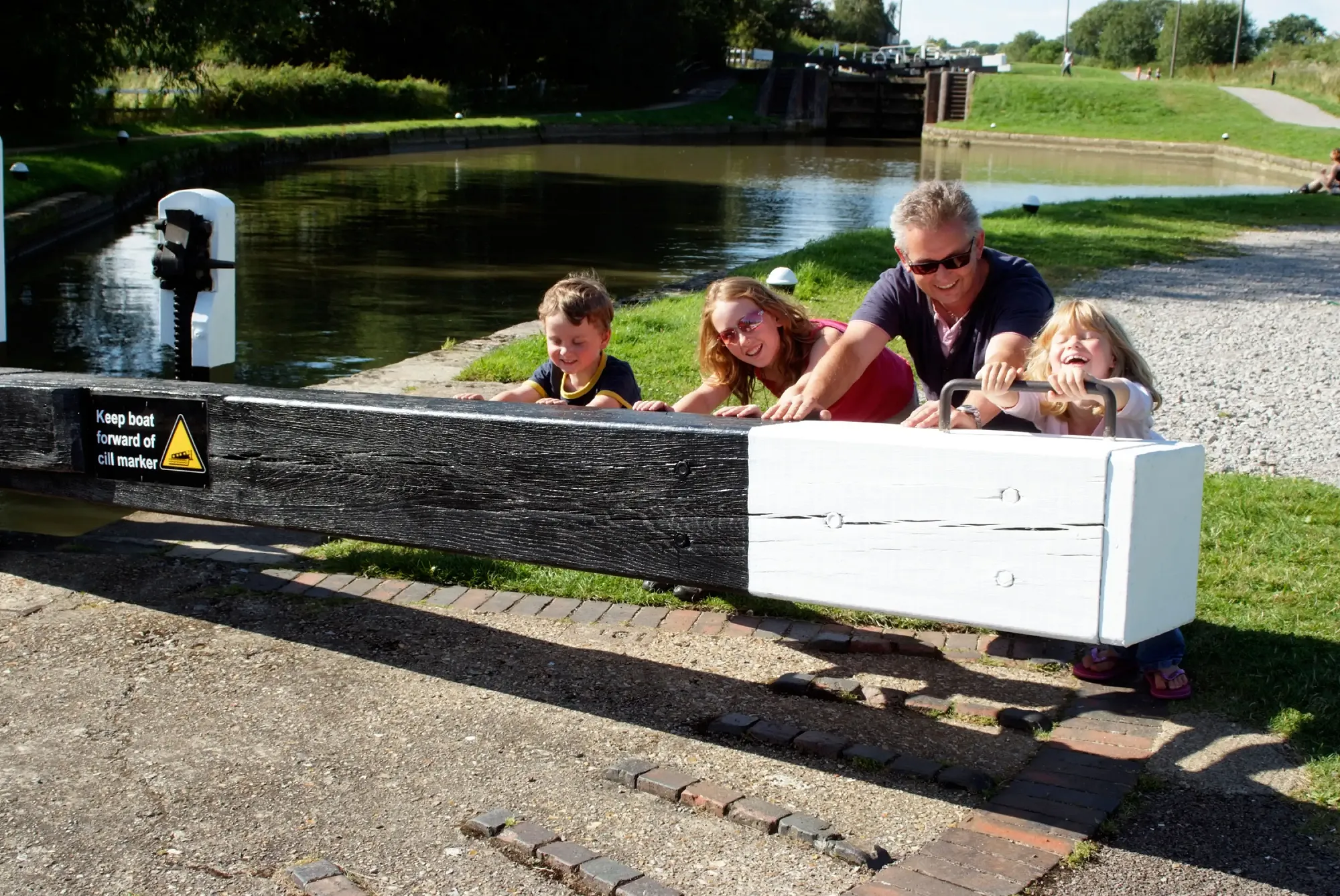 A family opening a a canal lock during a canal boat holiday