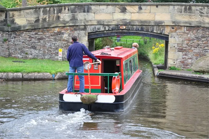 A couple on a canal boat holiday passing under bringe 31 on the Llangollen canal