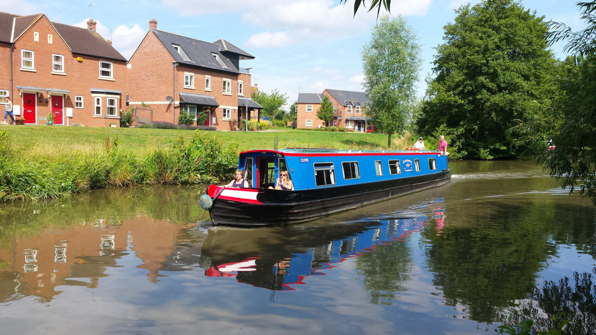 A family onboard a holiday narrowboat cruising down the canal